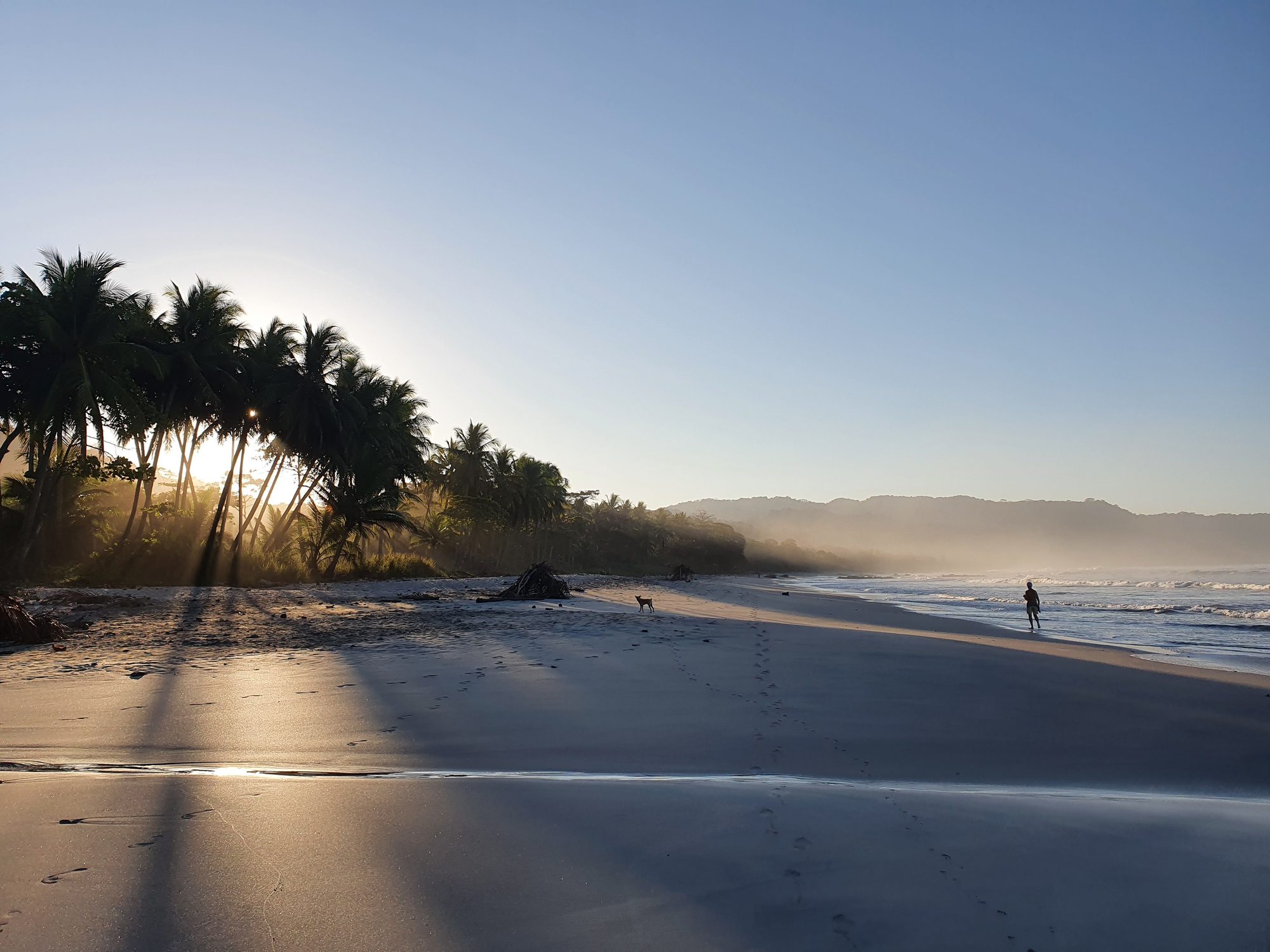 A Santa Teresa beach at golden hour, surf rolling in
