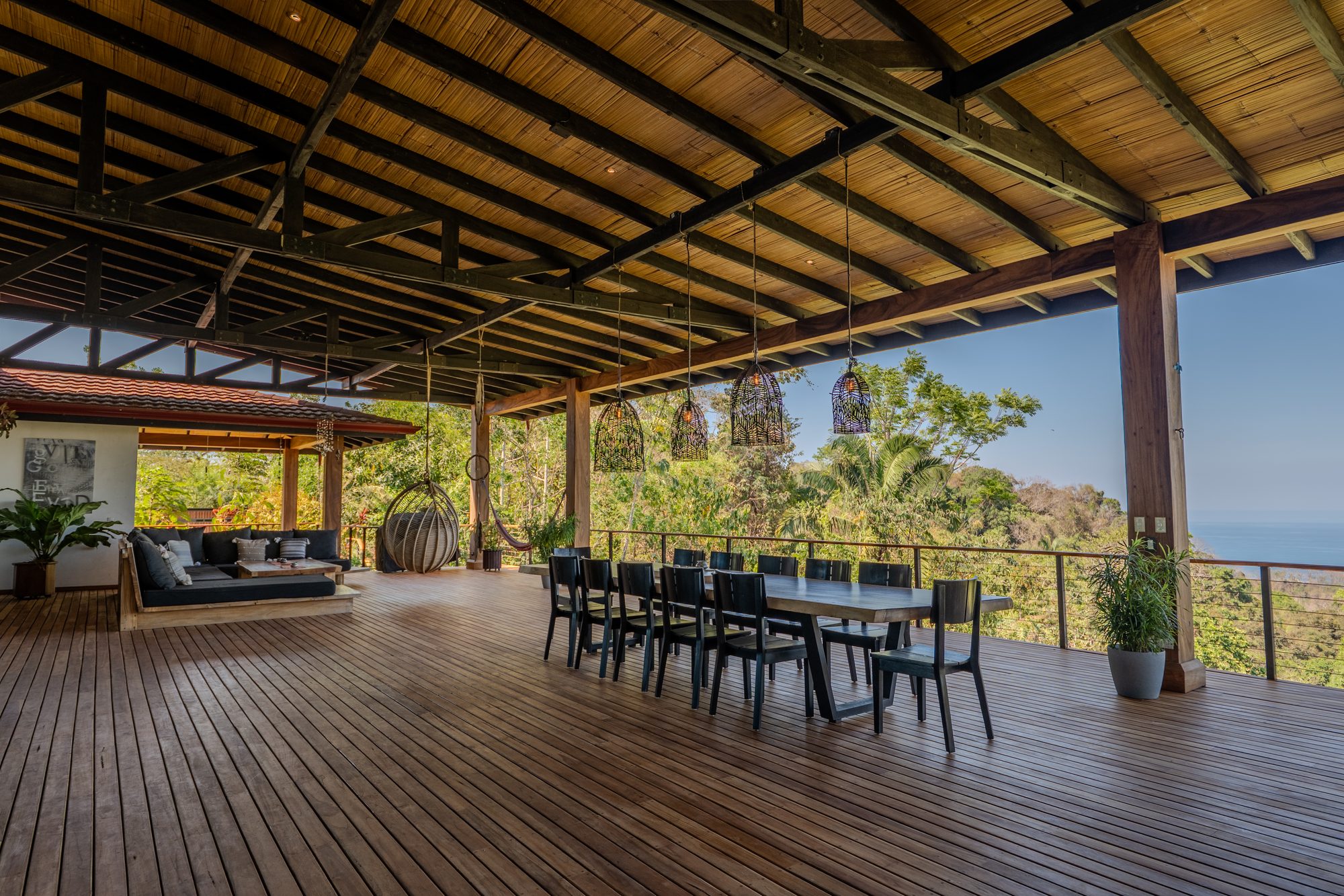 The covered deck with alfresco dining and lounge at sunset