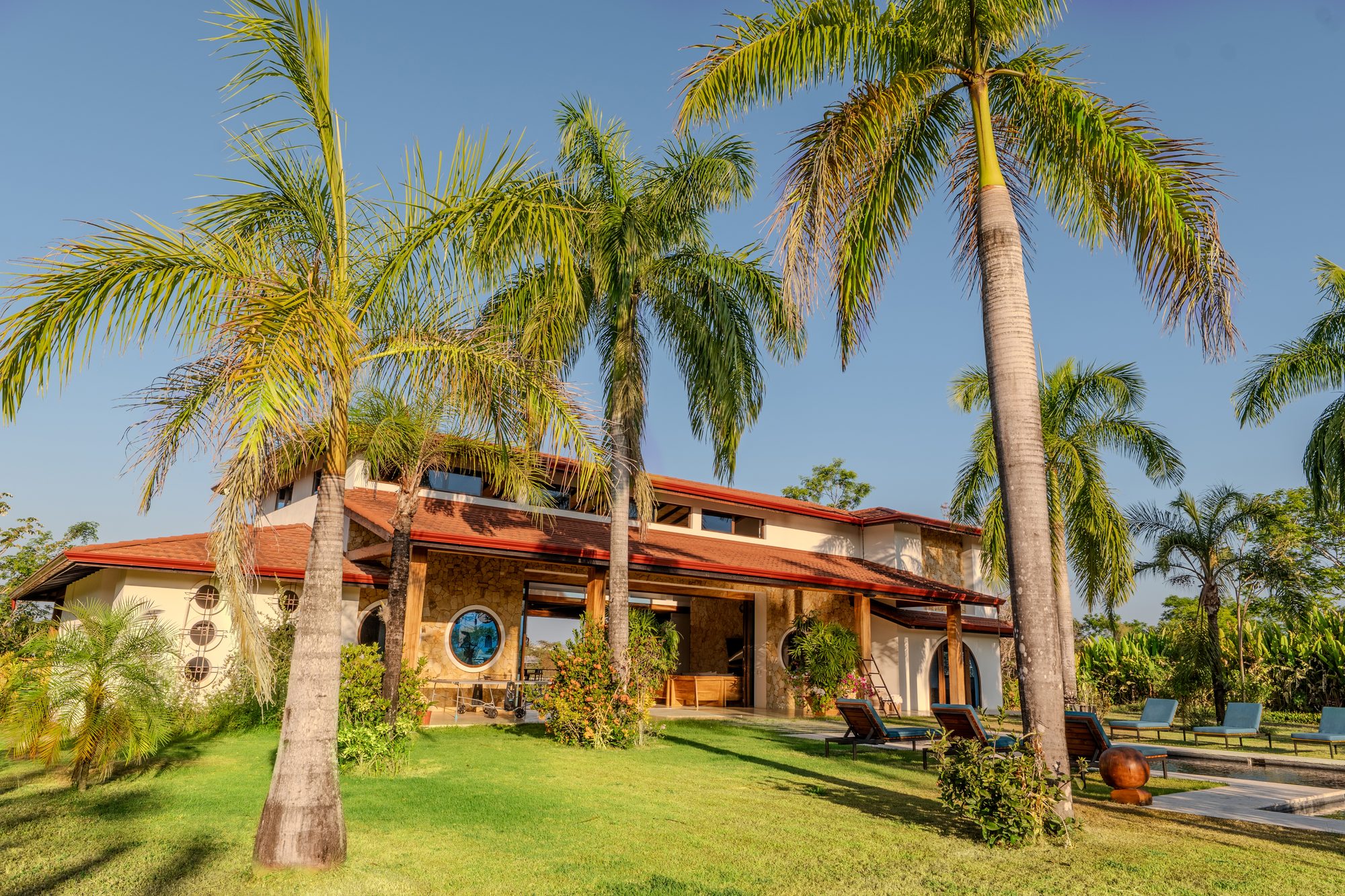 The villa exterior framed by royal palms