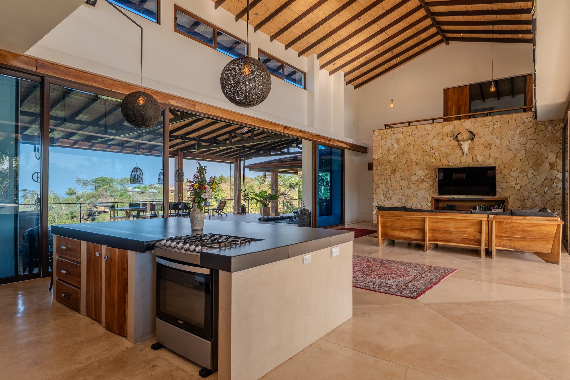 The full chef's kitchen with stone wall and island seating